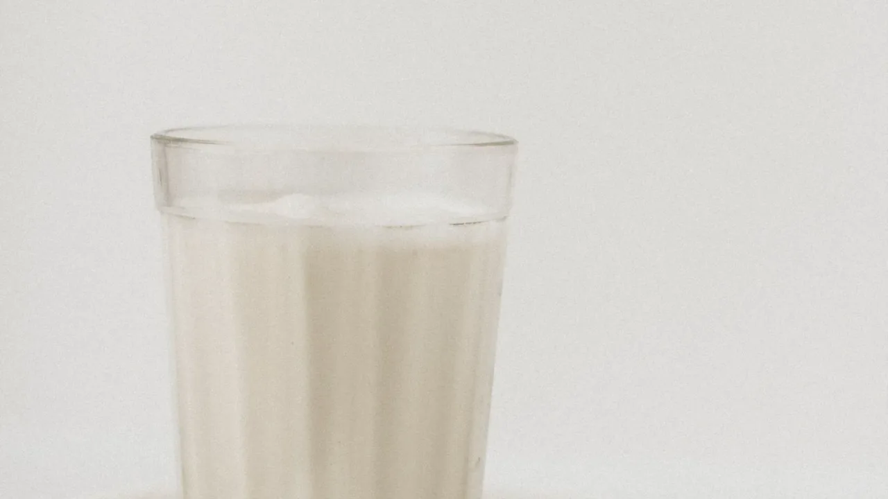 Beyaz zemin üzerinde bardakta kefir