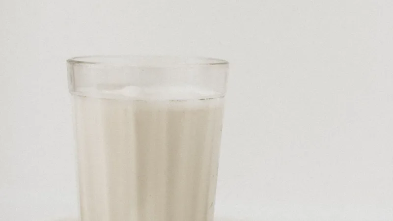 Beyaz zemin üzerinde bardakta kefir